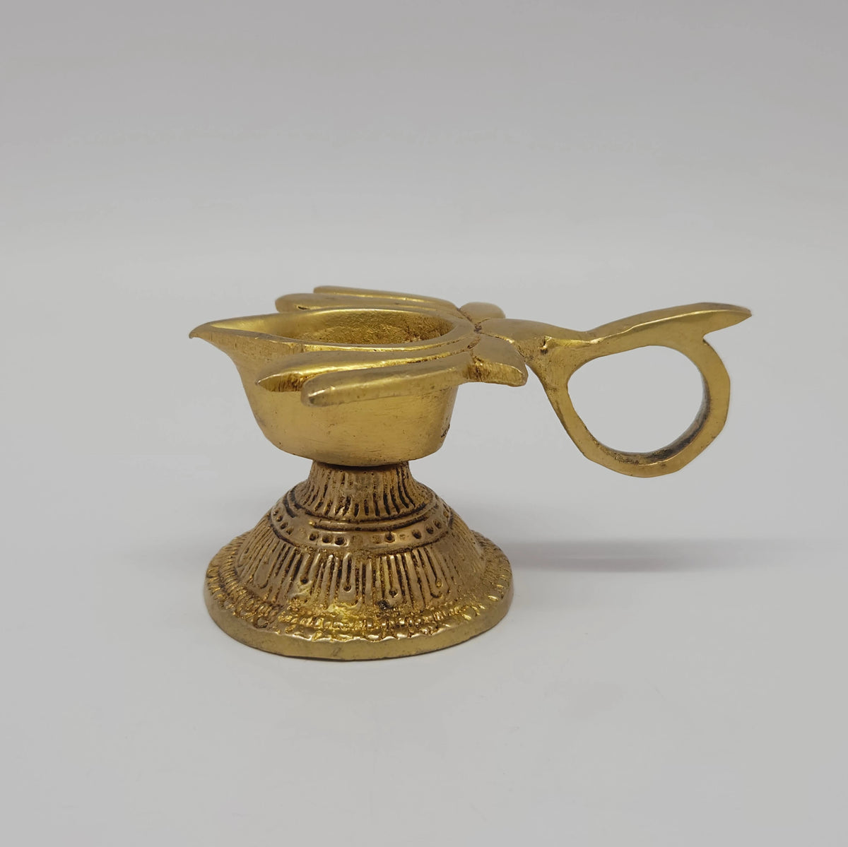 Sharp side profile view of the premium solid brass lotus handled arati lamp demonstrating the eight point five centimeter length clearance and flared base lines by Sri Swaminathan and Co.