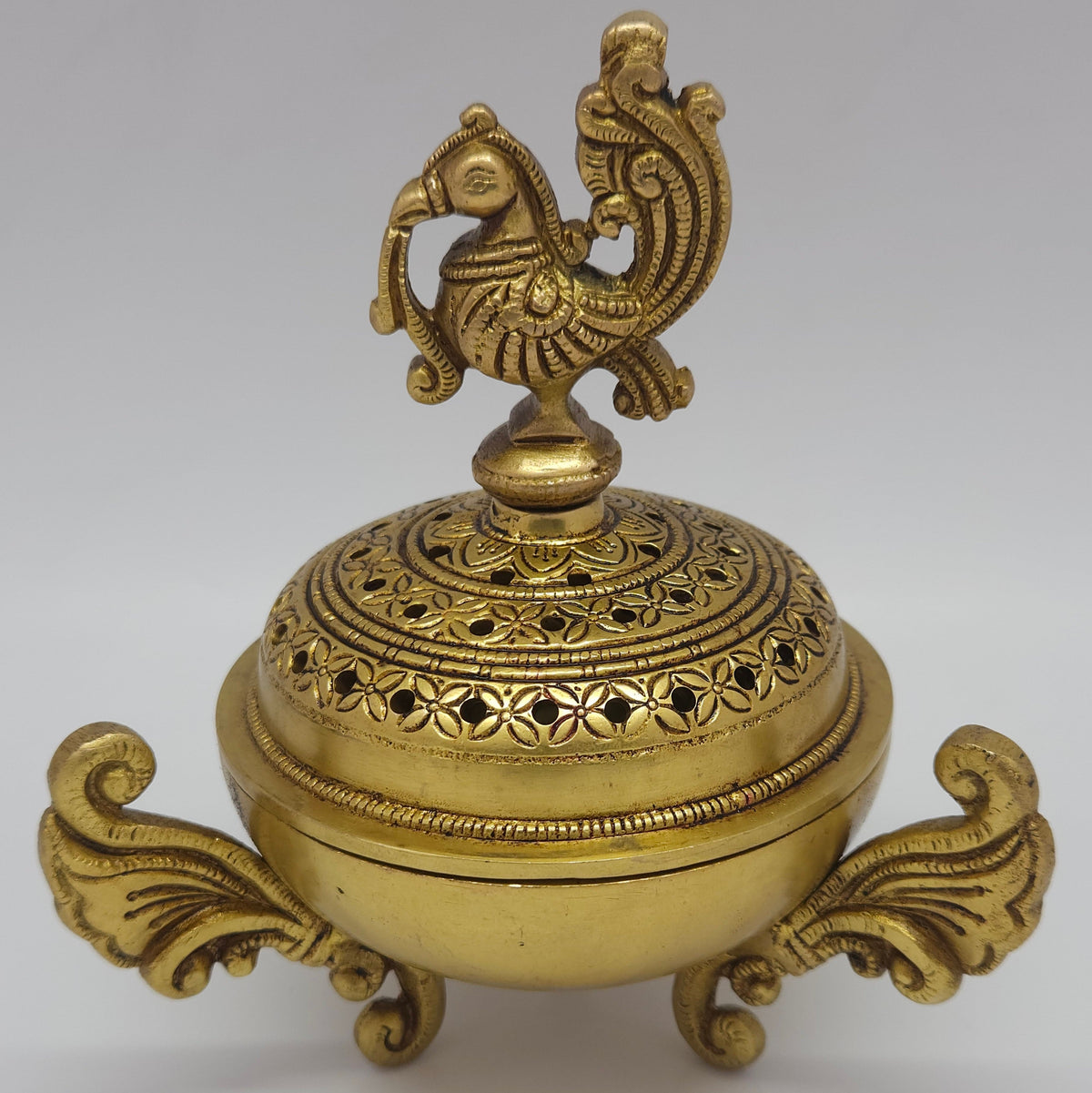Direct straight front profile view of the premium solid brass Peacock dhoop dhani holder showing the ornate winged handles and closed dome lid by Sri Swaminathan and Co.