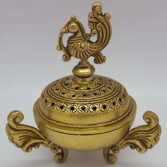 Direct straight front profile view of the premium solid brass Peacock dhoop dhani holder showing the ornate winged handles and closed dome lid by Sri Swaminathan and Co.