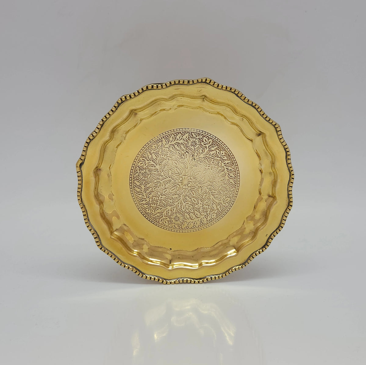  Direct straight front view of the premium solid brass pooja plate highlighting the intricate central engraving and raised royal pebble border by Sri Swaminathan and Co.
