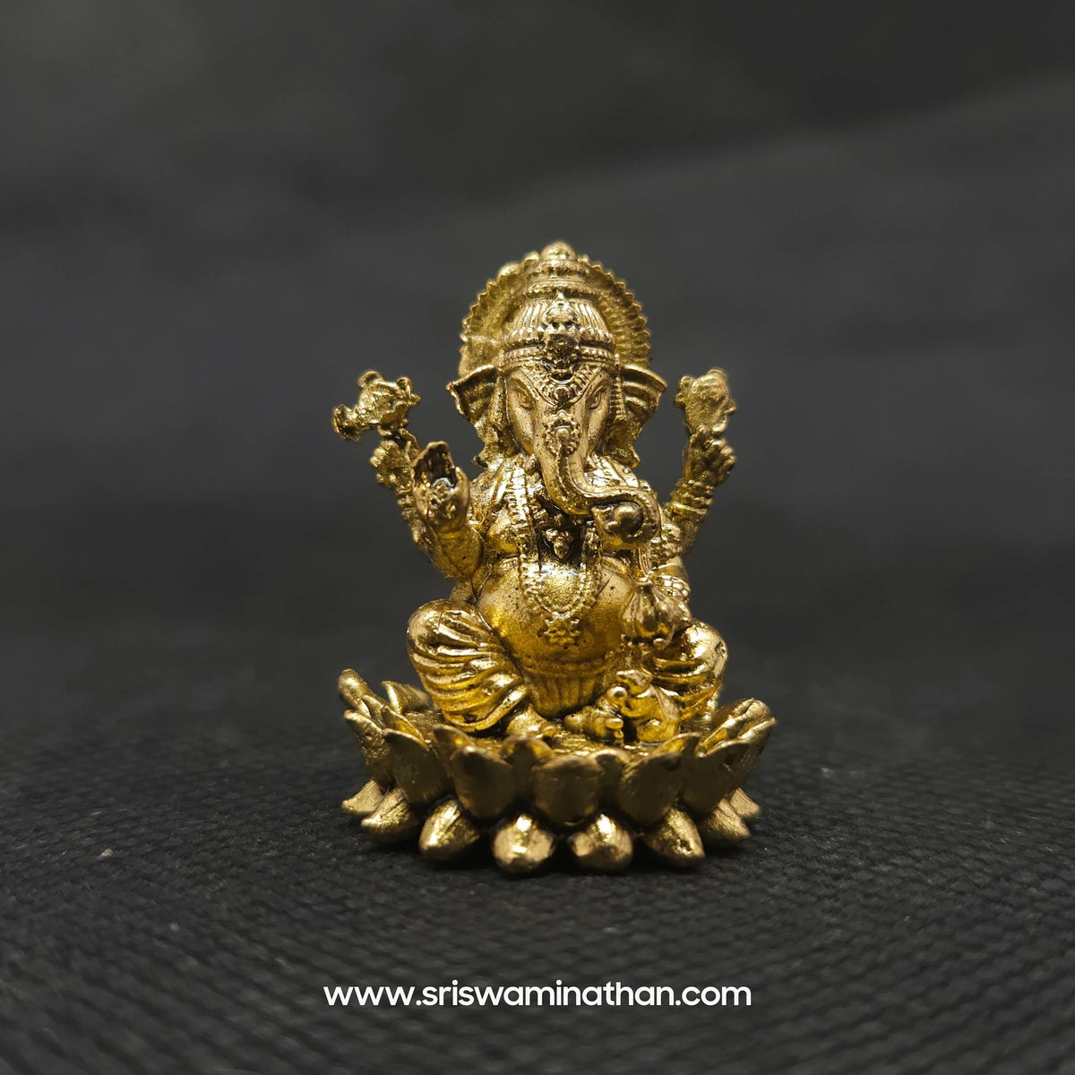  Straight front view of the one inch premium brass Ganesha statue showing the Lord and Mooshikan seated together on a double-bloomed round lotus peedam base by Sri Swaminathan and Co.
