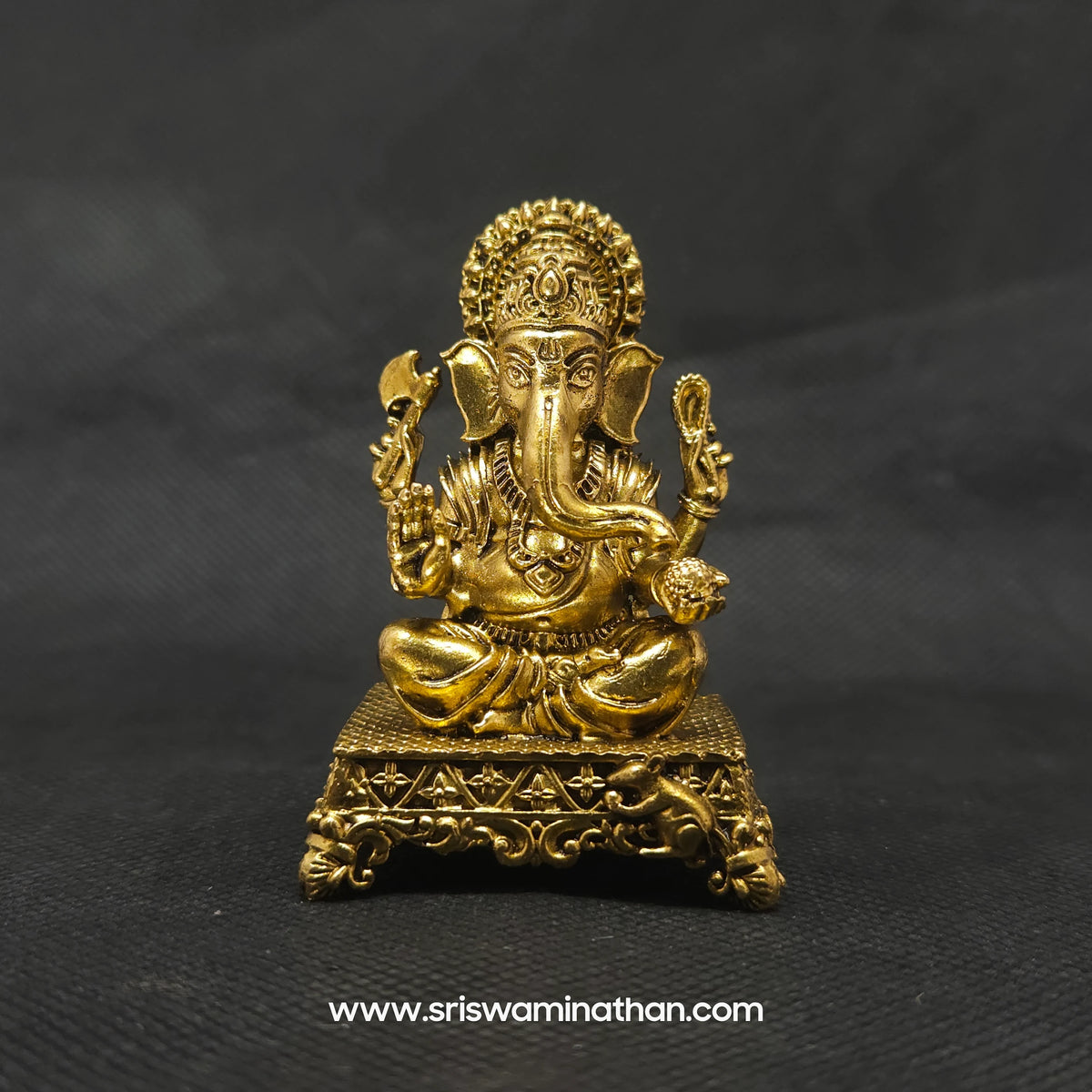 Straight front view of the premium solid brass seated Ganesha statue showing the Lord on an ornate square peedam with Mooshika by Sri Swaminathan and Co