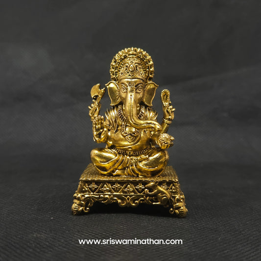 Straight front view of the premium solid brass seated Ganesha statue showing the Lord on an ornate square peedam with Mooshika by Sri Swaminathan and Co