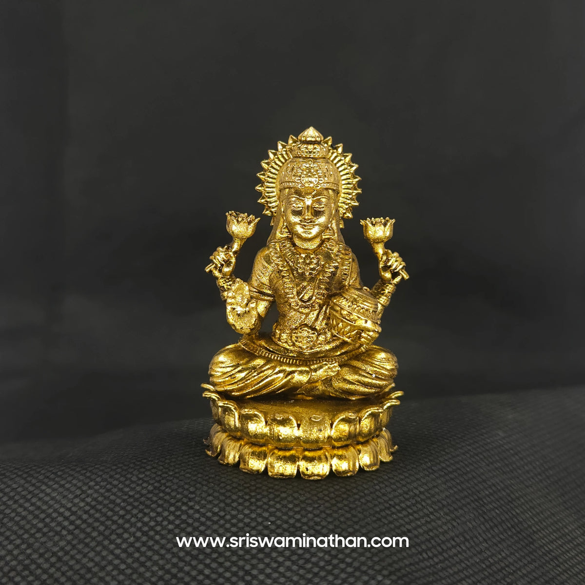 Straight front view of the premium solid brass seated Lakshmi statue showing the goddess holding an Akshaya Patram vessel on a round lotus peedam by Sri Swaminathan and Co.