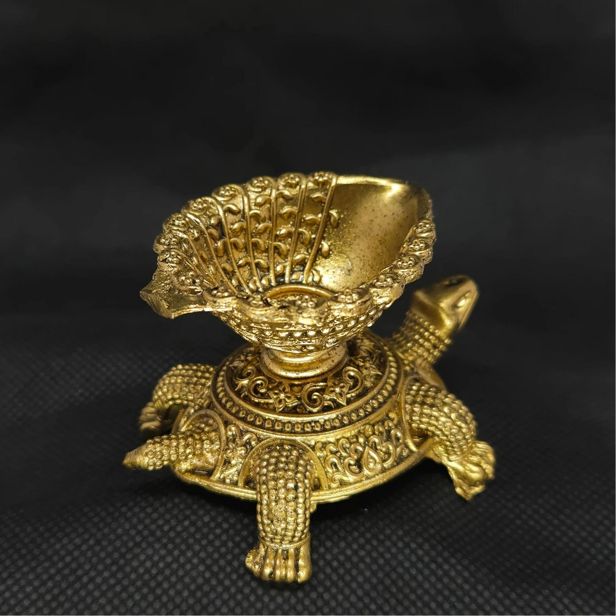 Direct straight back view of the solid brass Tortoise vilakku lamp demonstrating the detailed rear surface of the chiseled oil reservoir and tail contours.