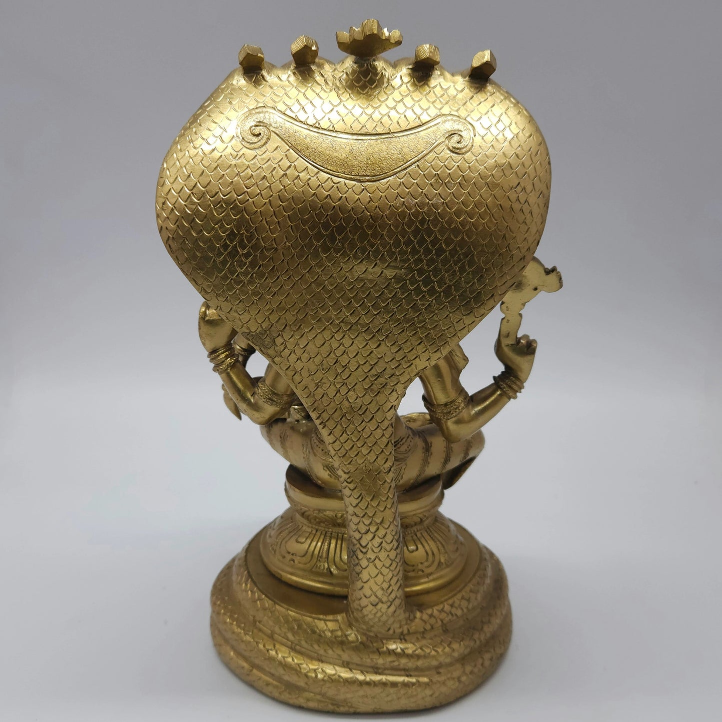 Full back view of the solid 8.2 kg lacquer polished brass Narasimha statue showing the textured rear side of the large Adisesha serpent hood