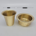 Top down angle view looking directly into the open brass gold finished bronze tumbler and dawara to highlight the polished inner liquid chambers