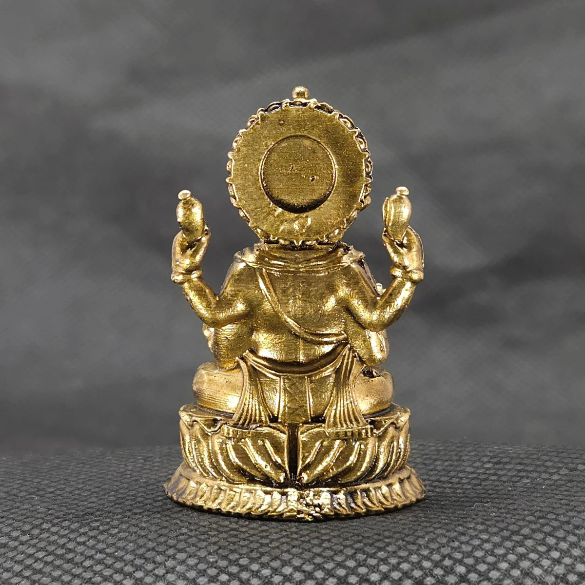 Direct straight back view of the one point seven five inch solid brass Ganesha statue demonstrating the detailed rear surface of the sunburst halo crown and back base curves.