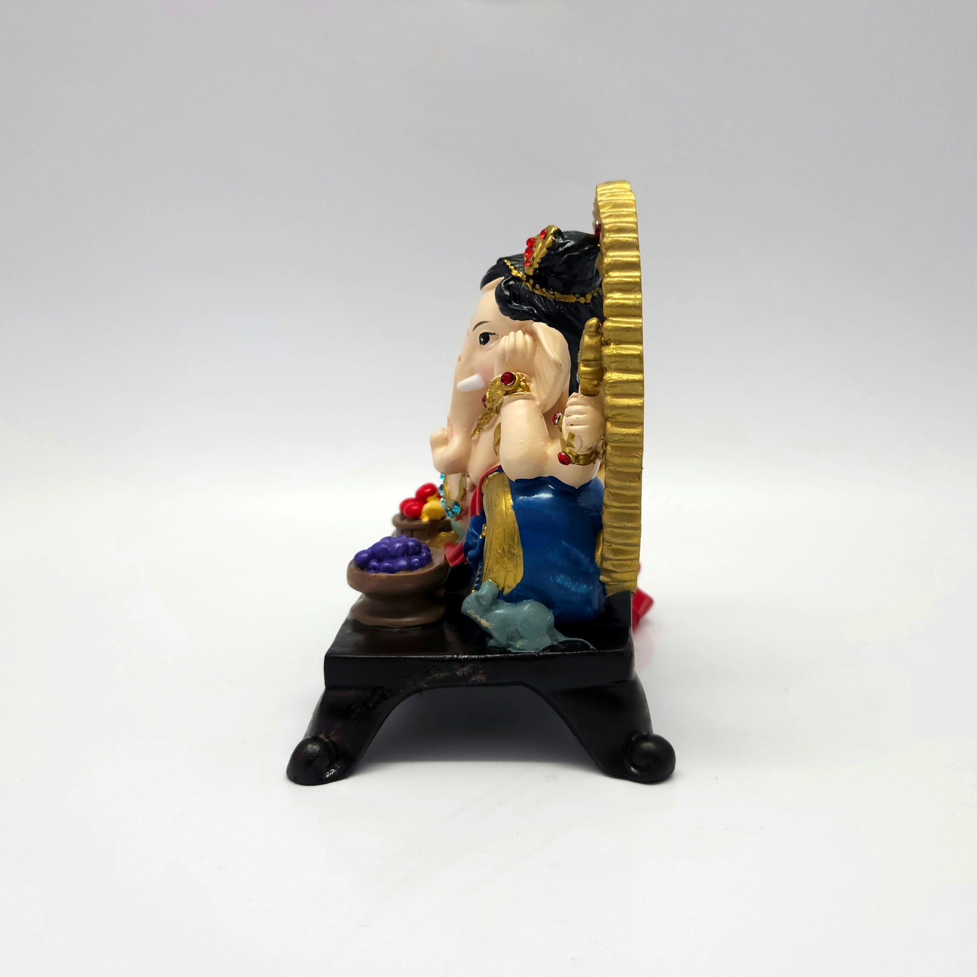 Right side view of a 6.3 inch reclining Ganesha figurine showing the thickness of the gold archway and sturdy dark pedestal legs.