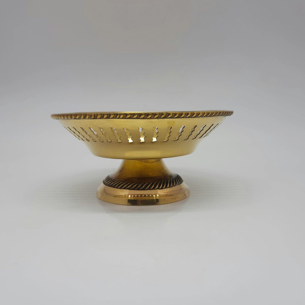 Straight front profile view of a single 14.5cm royal lattice cutwork brass pedestal bowl showcasing its braided rope border accents by Sri Swaminathan and Co.