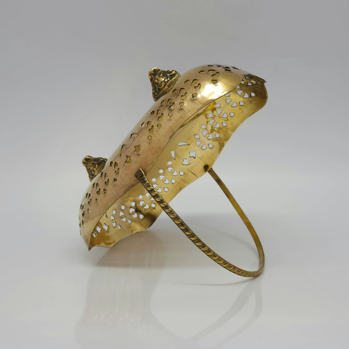 Angled presentation view showing the 17.5cm brass basket resting face down on its front rim to clearly showcase the four detailed ornate lion-claw support legs.