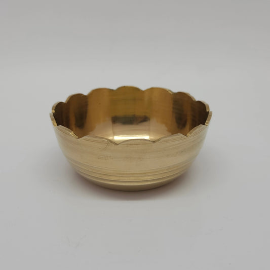 Three-quarter angled front profile view of the seven point two centimeter large brass lotus petal katori bowl highlighting the fluted bloomed rim layers.