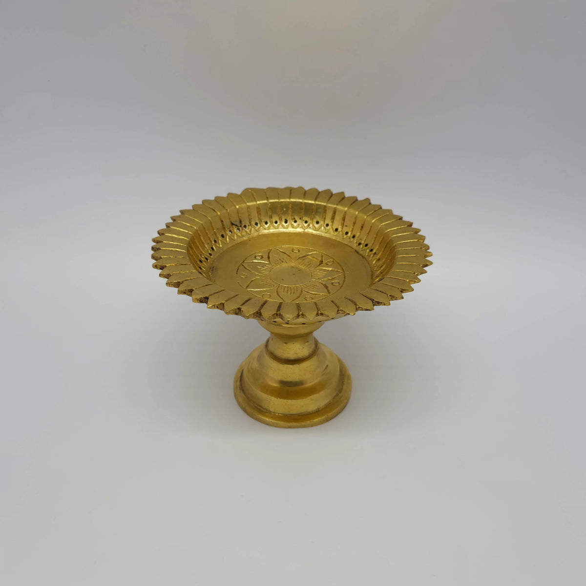 Three-quarter angled view of the heavy 1.050kg brass altar stand showing the inside capacity of the wide shallow basin.