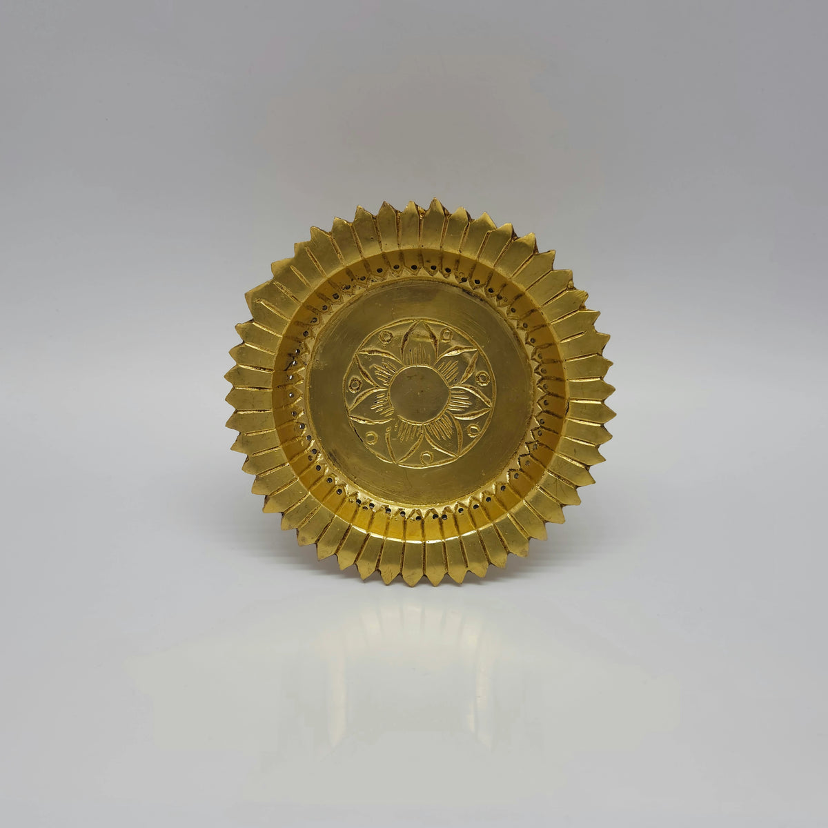 Straight top down view of the 14cm brass ritual stand highlighting the clean engraved star flower design centered at the inner base.