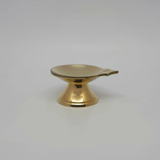 Straight front view of a single solid brass single-spout pedestal daily diya showcasing its high-gloss mirror polish by Sri Swaminathan and Co.