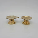 Front presentation view displaying two identical solid brass single-spout pedestal daily diyas standing side-by-side on a reflective background.