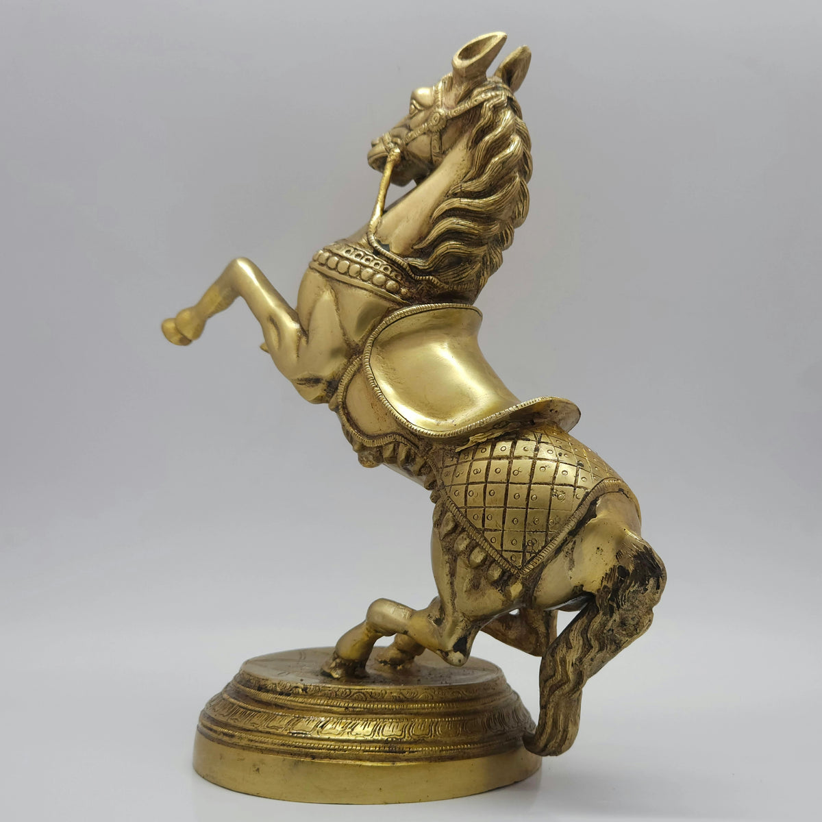 Three-quarter rear right perspective view of the thirteen point four inch brass rearing horse statue highlighting the thick textured flowing mane casting.