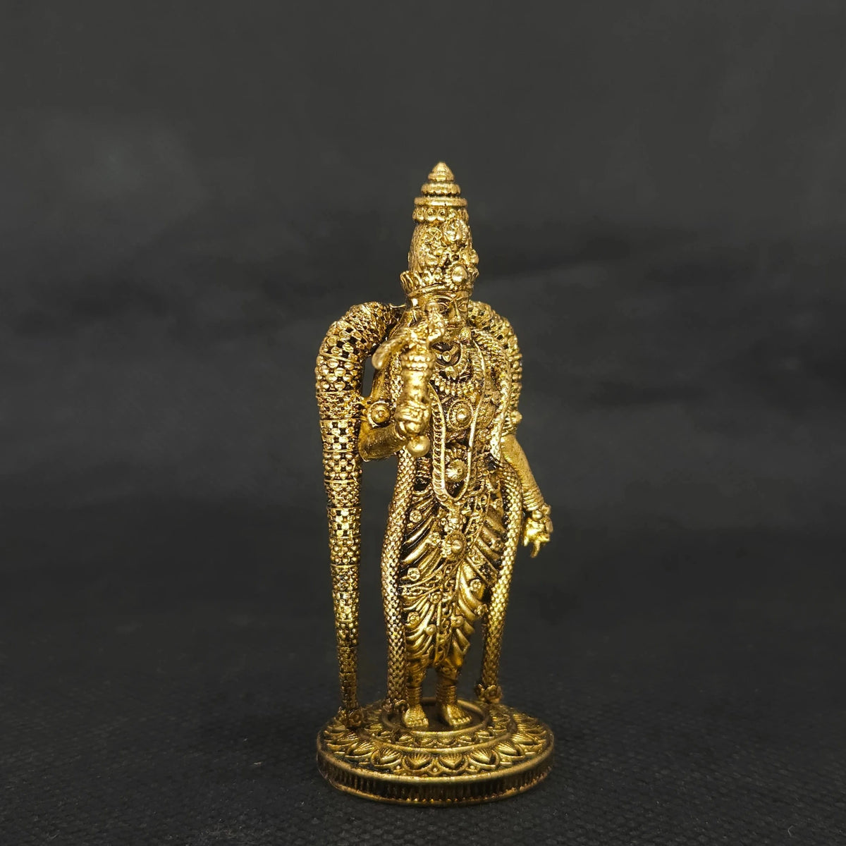 Three-quarter front left perspective view of the three inch brass Madurai Meenakshi amman statue highlighting her fine chiseled body contours and long silk saree folds