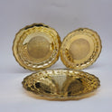 Display arrangement of three twelve inch premium brass royal pebble engraved pooja plates showcasing multiple sizes positioned together for an altar display set.