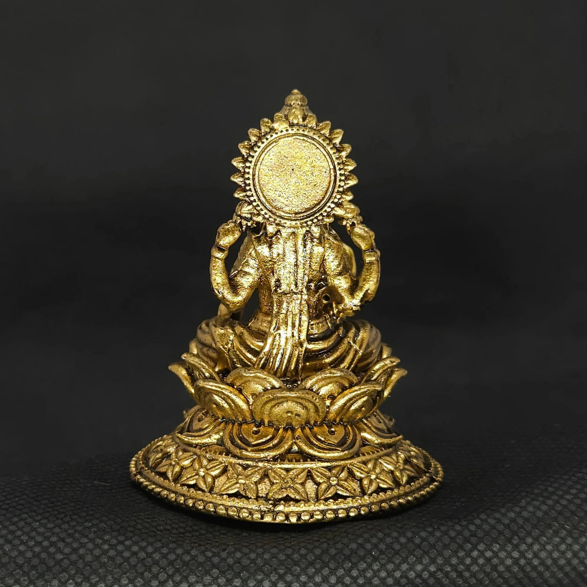 Direct straight back view of the solid brass Aishwarya Lakshmi statue demonstrating the detailed rear surface of the circular sunburst halo aura and smooth back base curves.