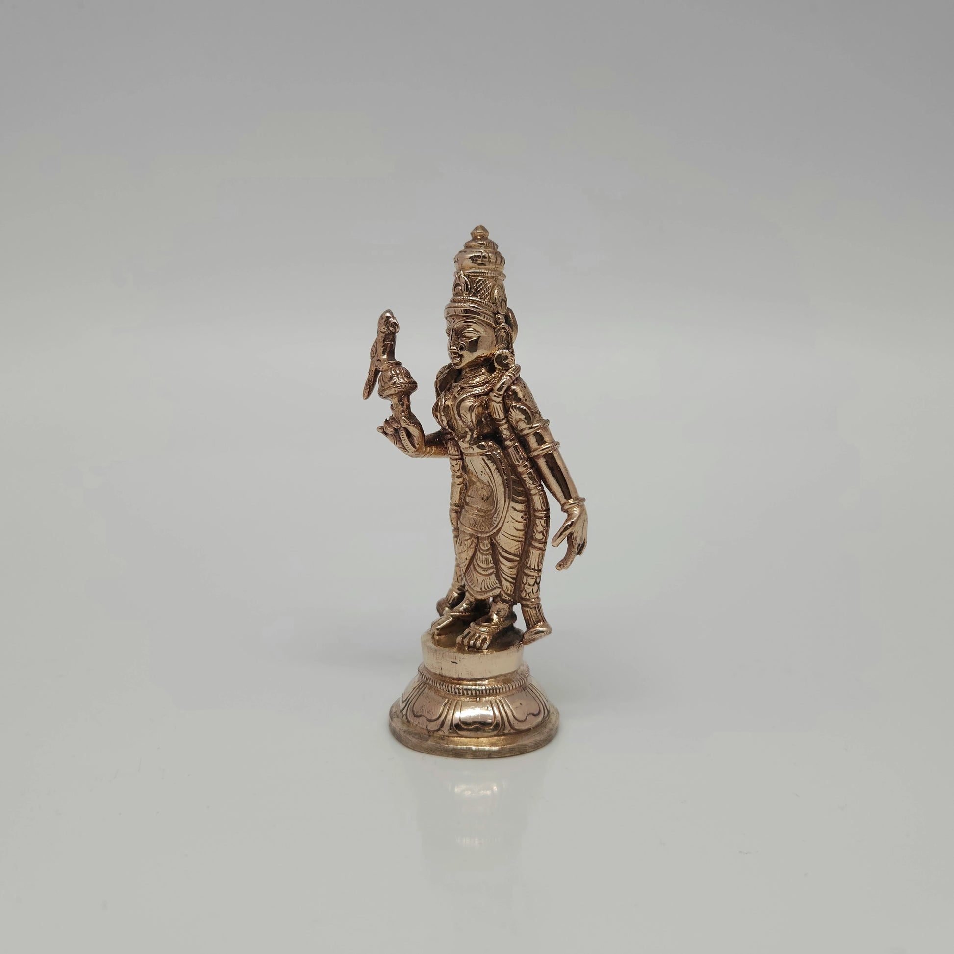 Three-quarter right perspective of the miniature solid cast Panchaloha Madurai Meenakshi statue showing the fine curves of her traditional dress.
