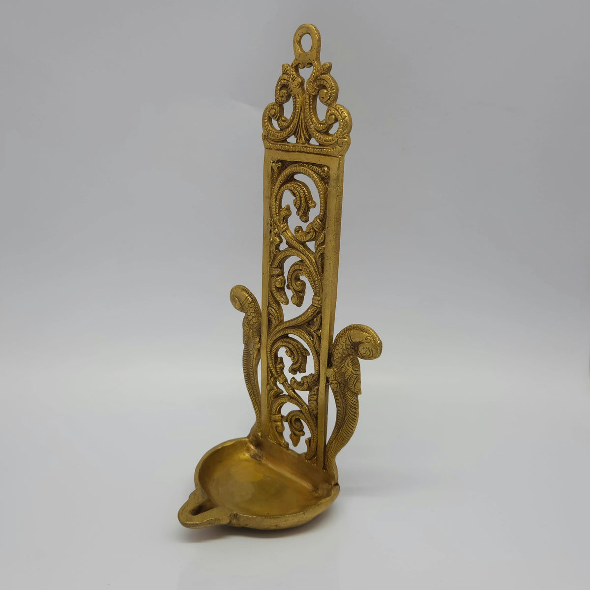 Three-quarter front left perspective view of the 900g vintage brass peacock hanging oil lamp showing the deep bottom bowl.