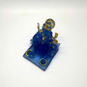 Overhead front look at the translucent ice-blue Ganpati idol highlighting the golden offering platters placed at the front