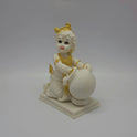 Three-quarter left angle view of an 18cm white marble-finish resin baby Krishna statue kneeling beside an overflowing butter pot by Sri Swaminathan and Co