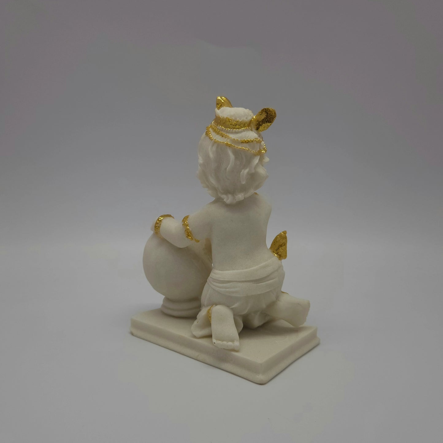 Full back view of the solid white resin baby Krishna idol showing the details of his hair locks and the smooth finish of the heavy base.