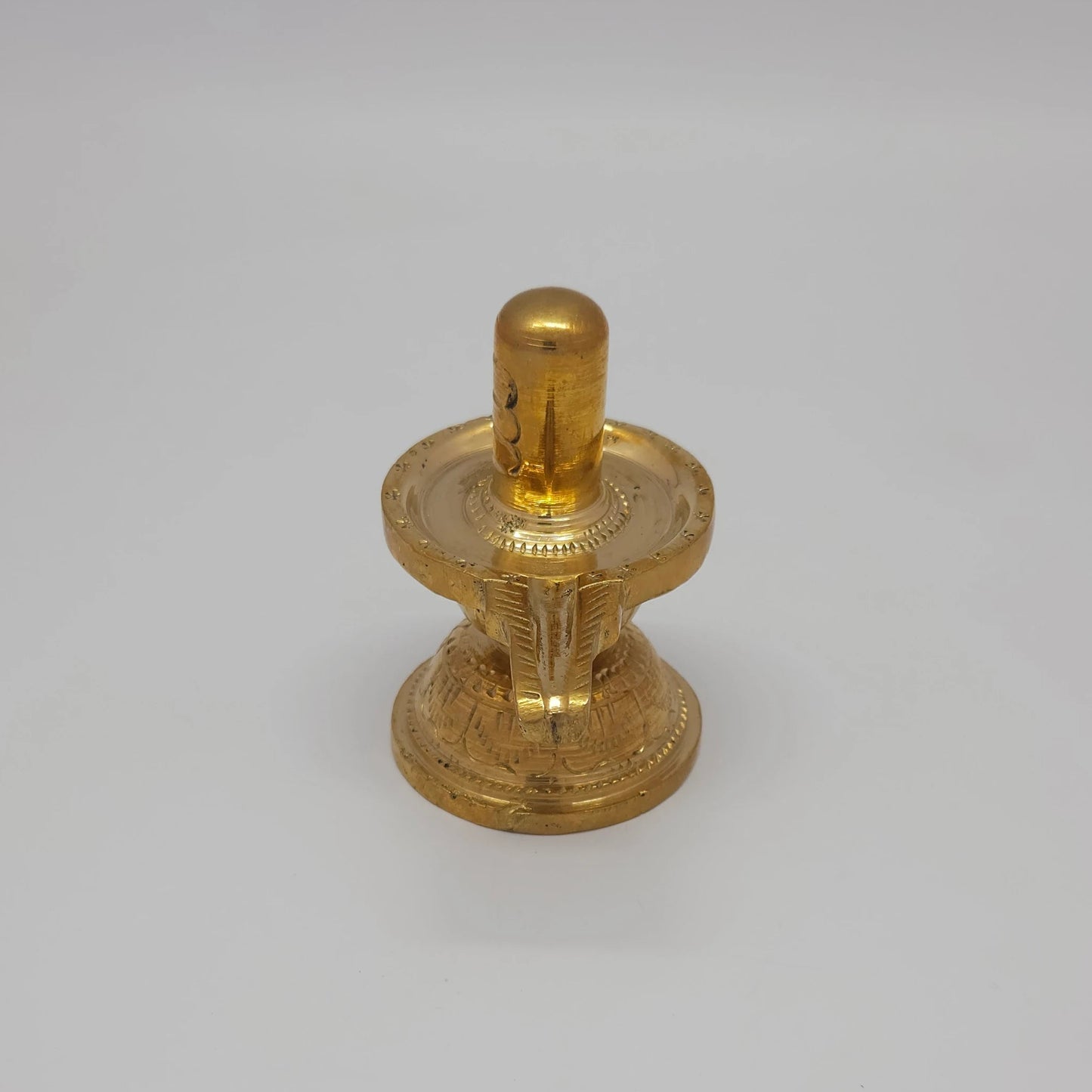 Sri Swaminathan and Co pure brass Shiva Lingam statue 8.5cm height 90-degree corner view focusing on the engraved padma peedam lotus base lines and spout 