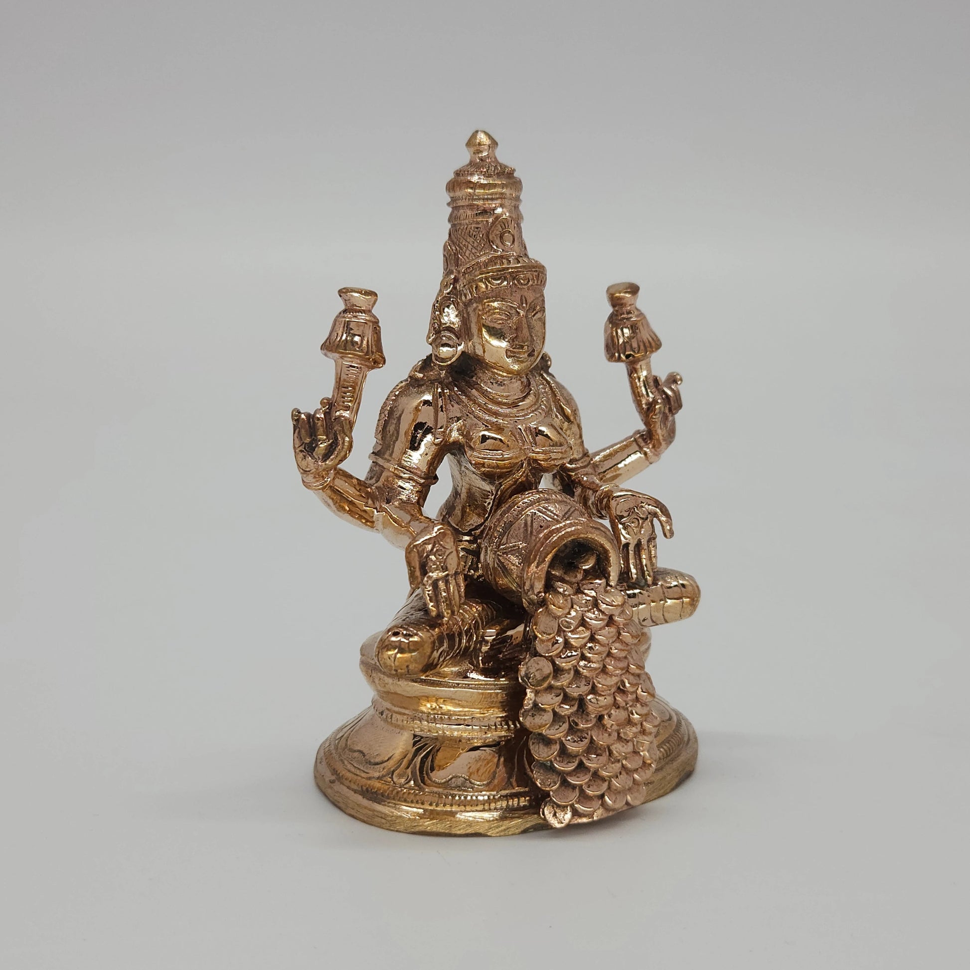 Sri Swaminathan and Co handcraft style Panchaloha Dhana Lakshmi statue 8.5cm height 45 degree left pose corner view highlighting lotus stalk and tilted coin pot