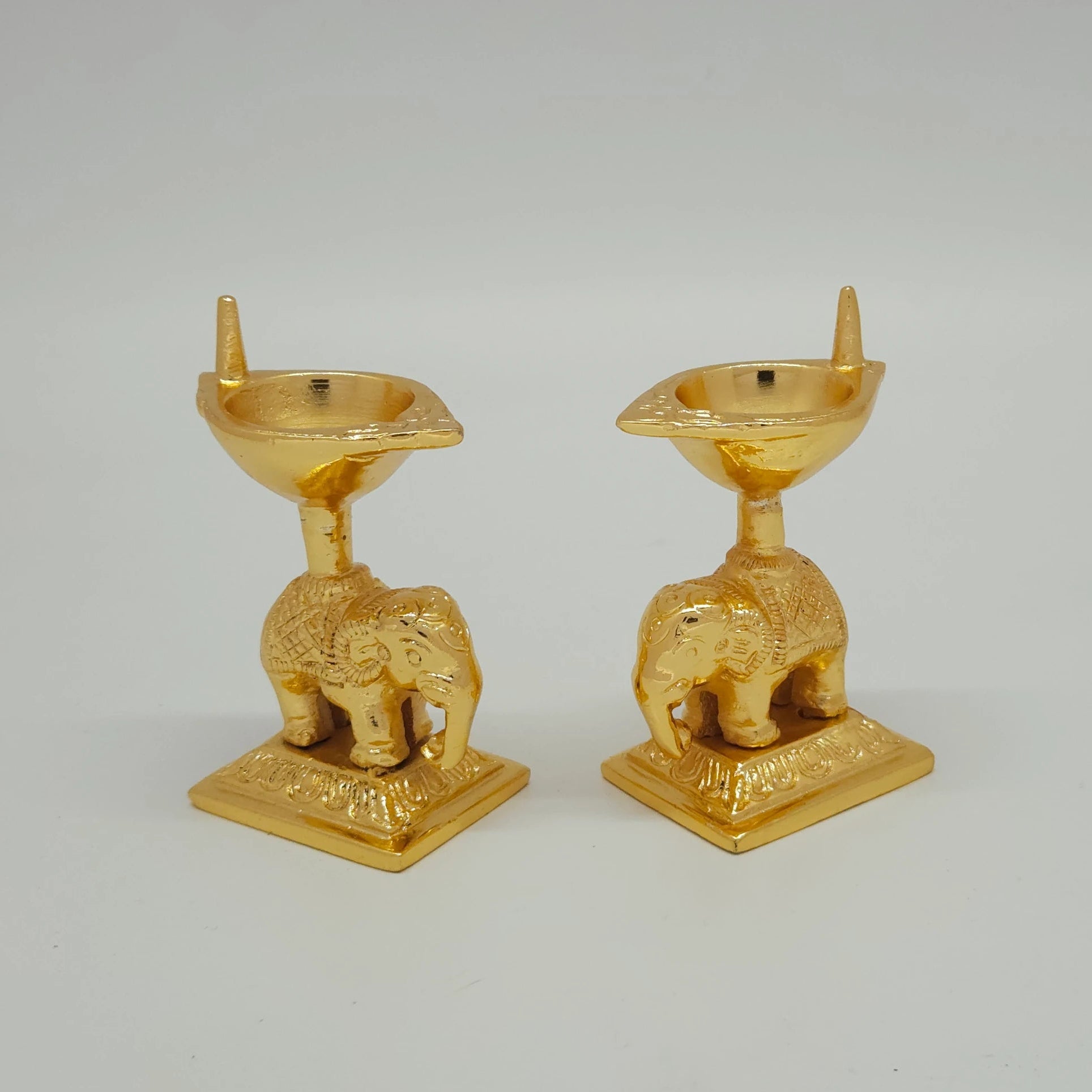 Sri Swaminathan and Co brass elephant diya stand gold powder coated 3 inch 8cm height 45 -egree side pose corner view highlighting single wick channel and elephant saddle pattern