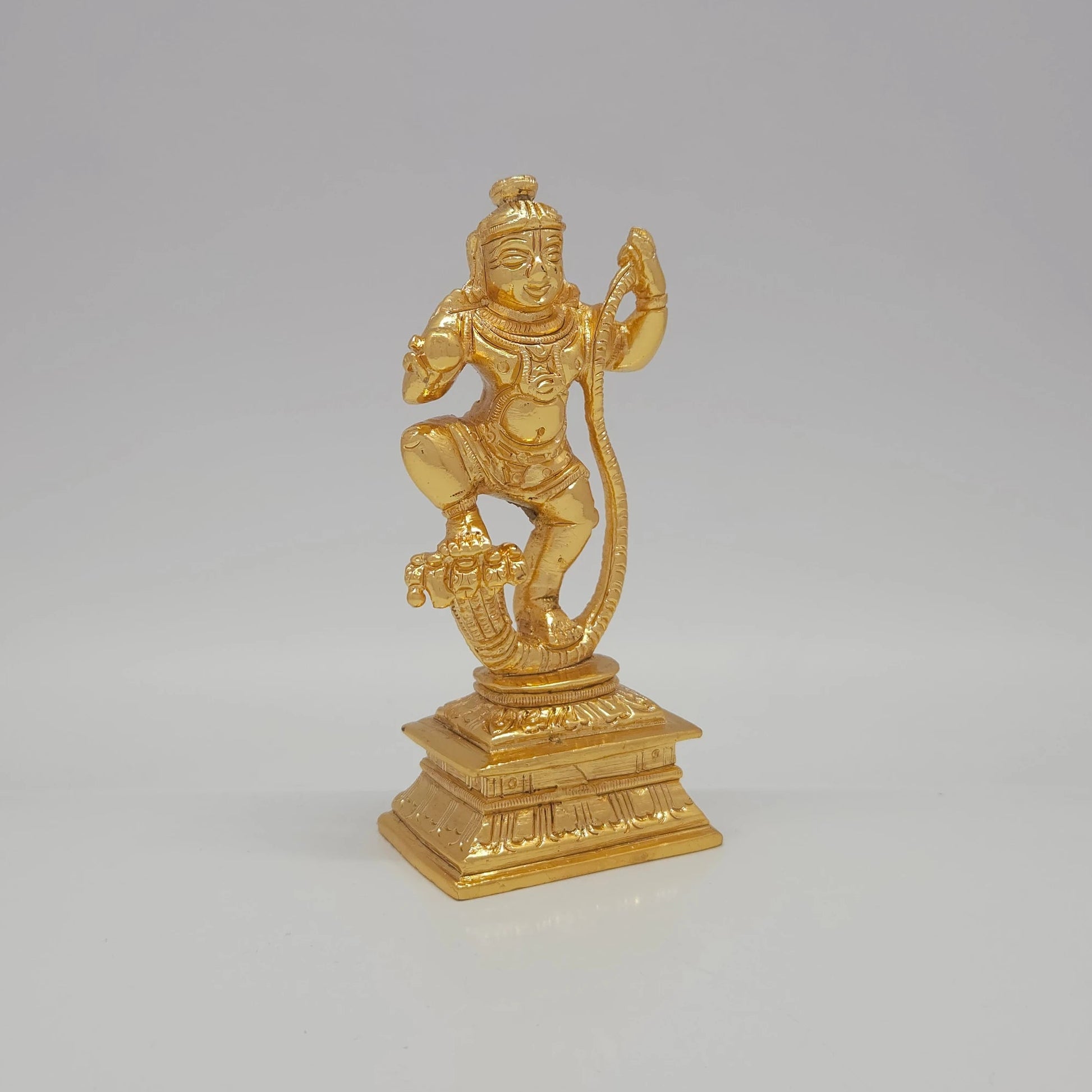 Sri Swaminathan and Co brass Kaliya Nartana Krishna statue gold finish 300g weight 45 degree right pose corner view focusing on dancing leg posture over multi headed serpent hood