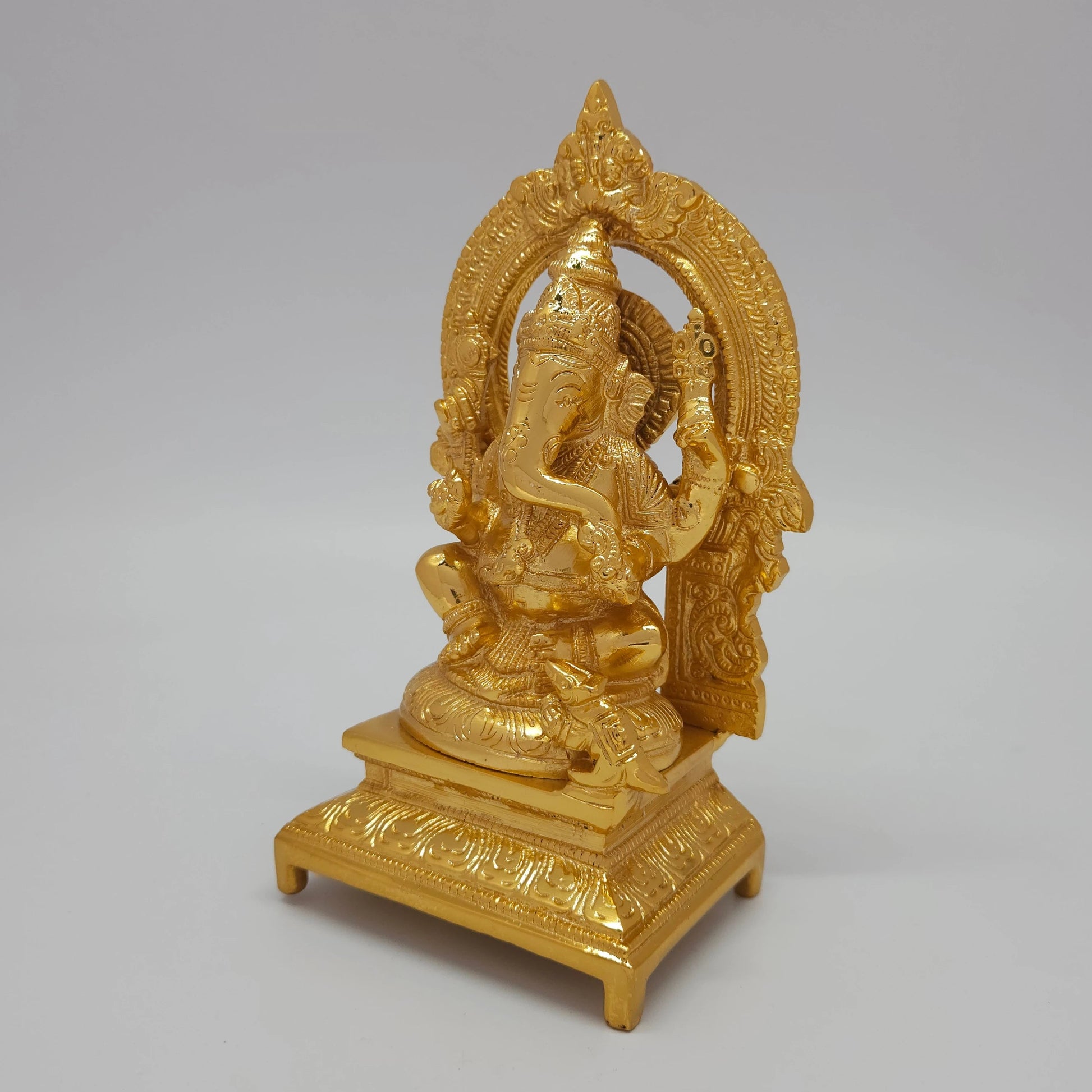 Sri Swaminathan and Co brass Ganesha statue with arch gold powder coated 7 inch 19cm height 45 degree left pose corner view highlighting ankusha weapon and trunk detail