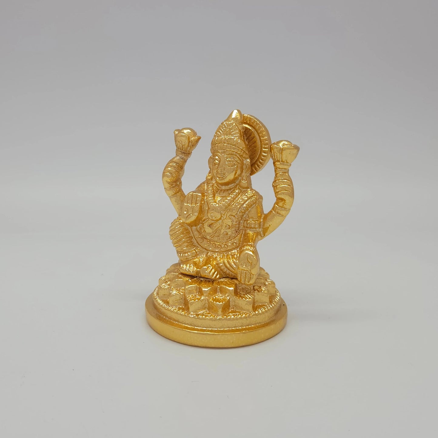 Sri Swaminathan and Co brass miniature Lalitasana Lakshmi statue gold finish 230g weight 45 degree left pose corner view highlighting the upper left lotus bud and tiered base ring depth