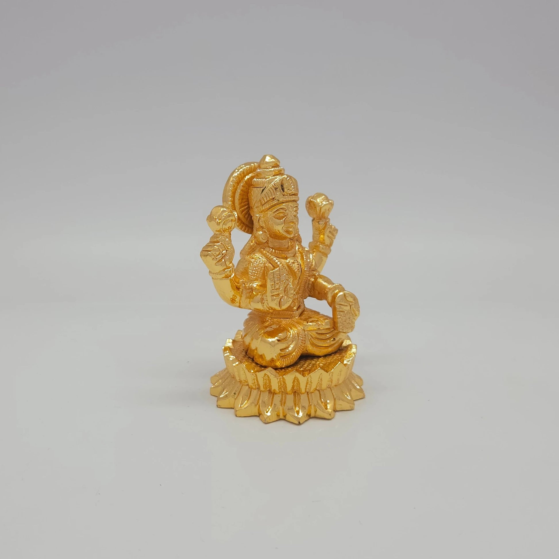 Sri Swaminathan and Co brass miniature Mahalakshmi statue gold finish 200g weight 45 degree right pose corner view focusing on protective abhaya mudra hand and circular lotus peedam diameter