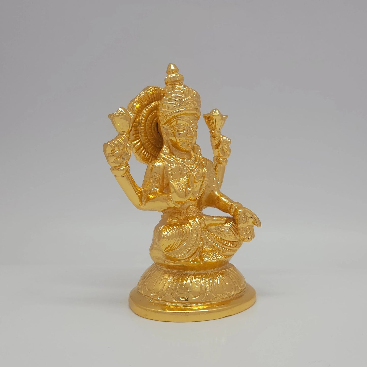Sri Swaminathan and Co brass Padmasana Mahalakshmi statue gold finish 750g weight 45 degree right pose corner view focusing on protective abhaya mudra hand and round base depth
