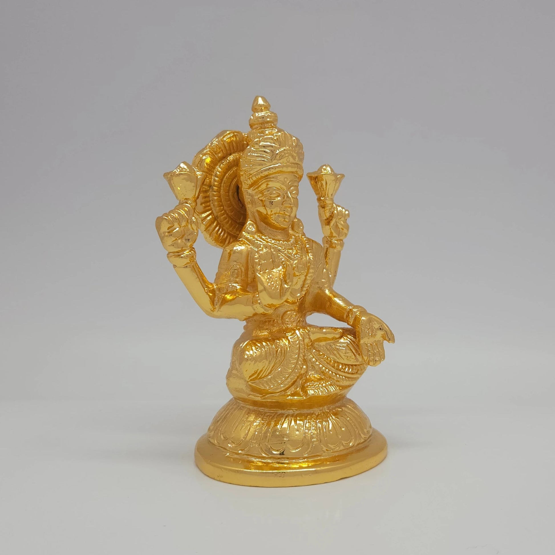 Sri Swaminathan and Co brass Padmasana Mahalakshmi statue gold finish 750g weight 45 degree right pose corner view focusing on protective abhaya mudra hand and round base depth
