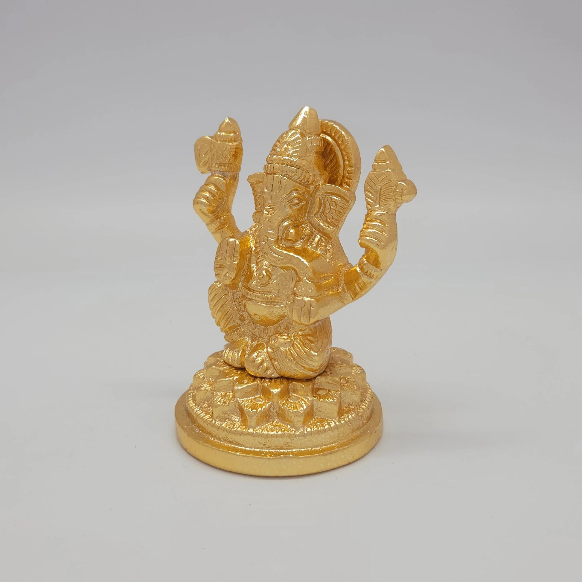 Sri Swaminathan and Co brass miniature Petal Series Ganesha statue gold finish 250g weight 45 degree left pose corner view highlighting the upper left attribute and ear lines