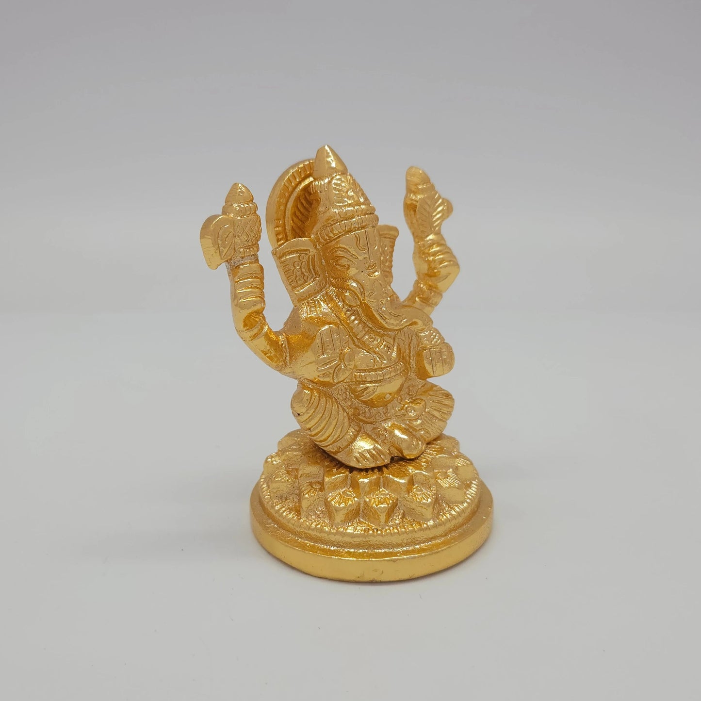 Sri Swaminathan and Co brass miniature Petal Series Ganesha statue gold finish 250g weight 45 degree right pose corner view focusing on raised right palm and base rim diameter