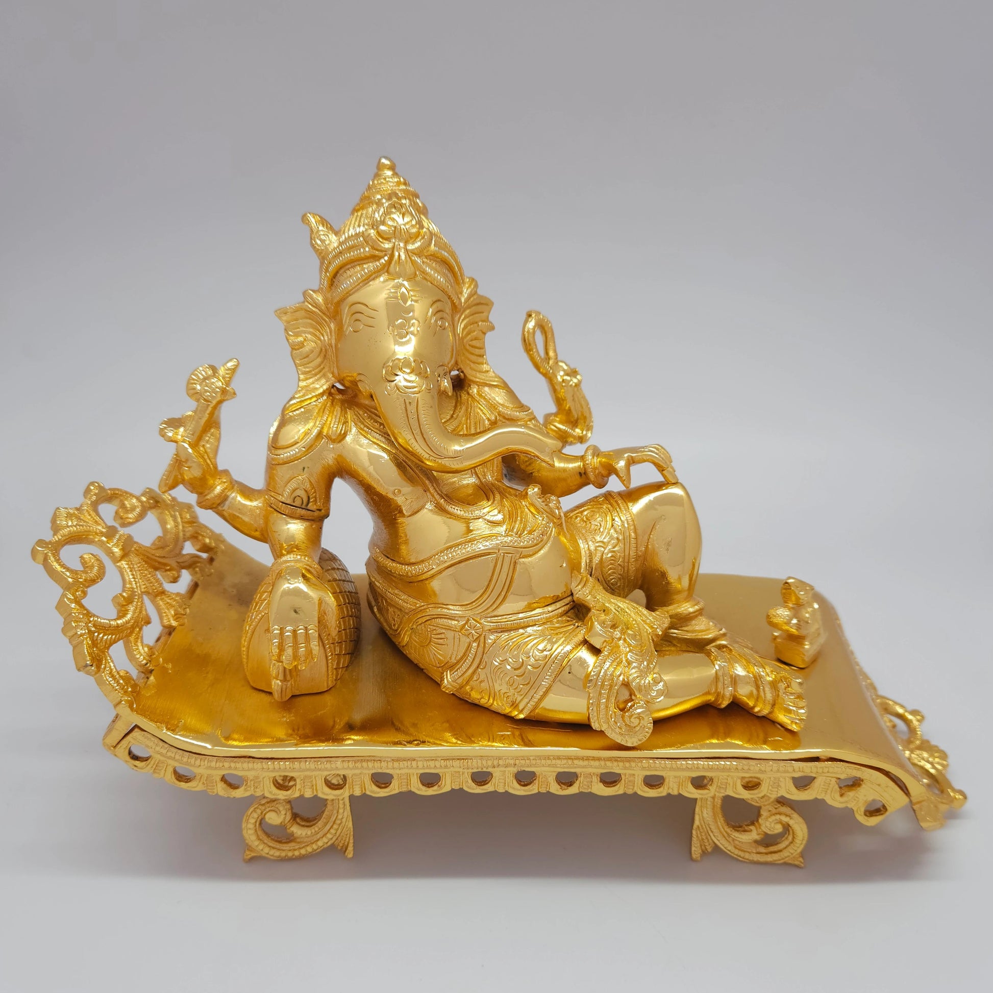 Sri Swaminathan and Co premium brass reclining Lord Ganesha statue on royal couch gold powder coated finish 11 inch 27cm length front straight profile view