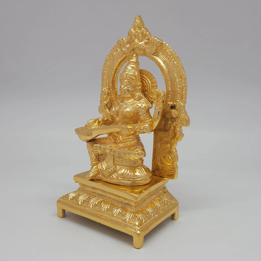 Sri Swaminathan and Co brass Sharada Saraswathi statue gold finish 1.37kg weight 45 degree left pose corner view highlighting veena neck pegs and palm leaf scripture details