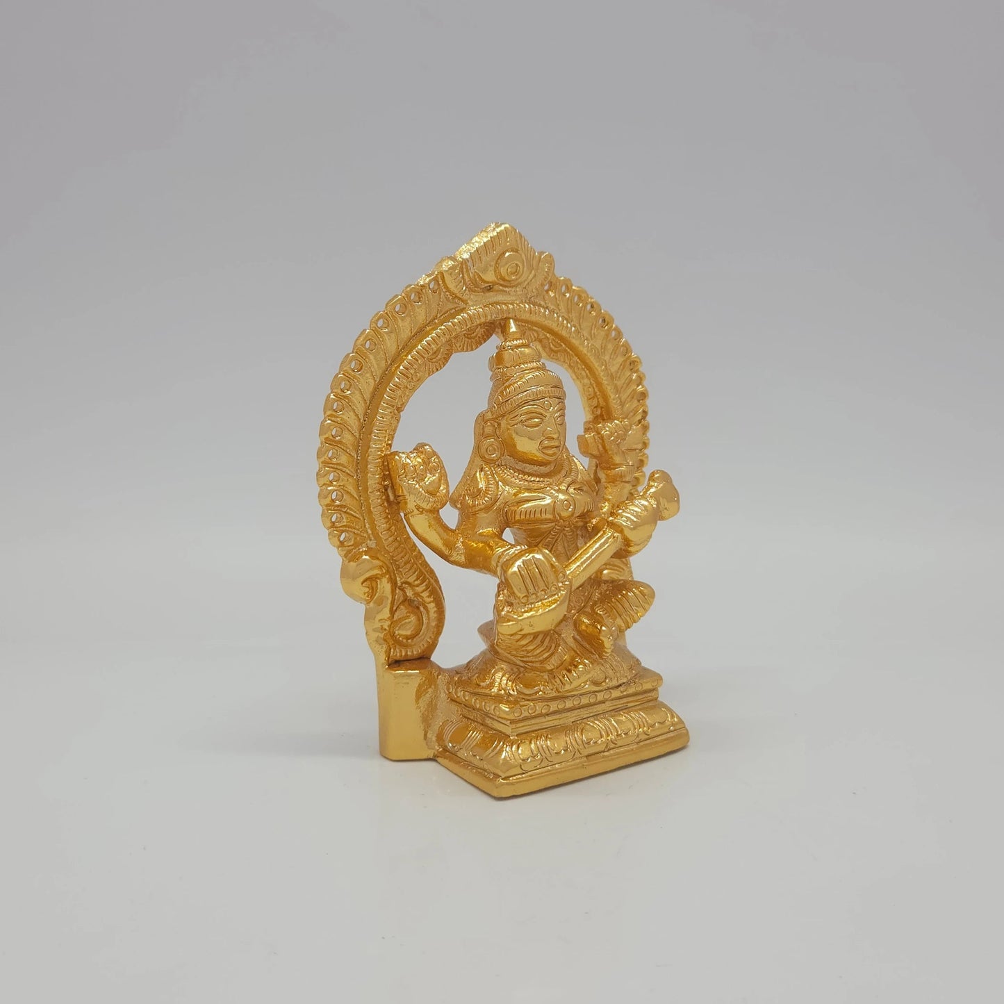 Sri Swaminathan and Co brass miniature Sharada Saraswathi statue gold finish 250g weight 45 degree right pose corner view focusing on veena neck alignment and rectangular base depth