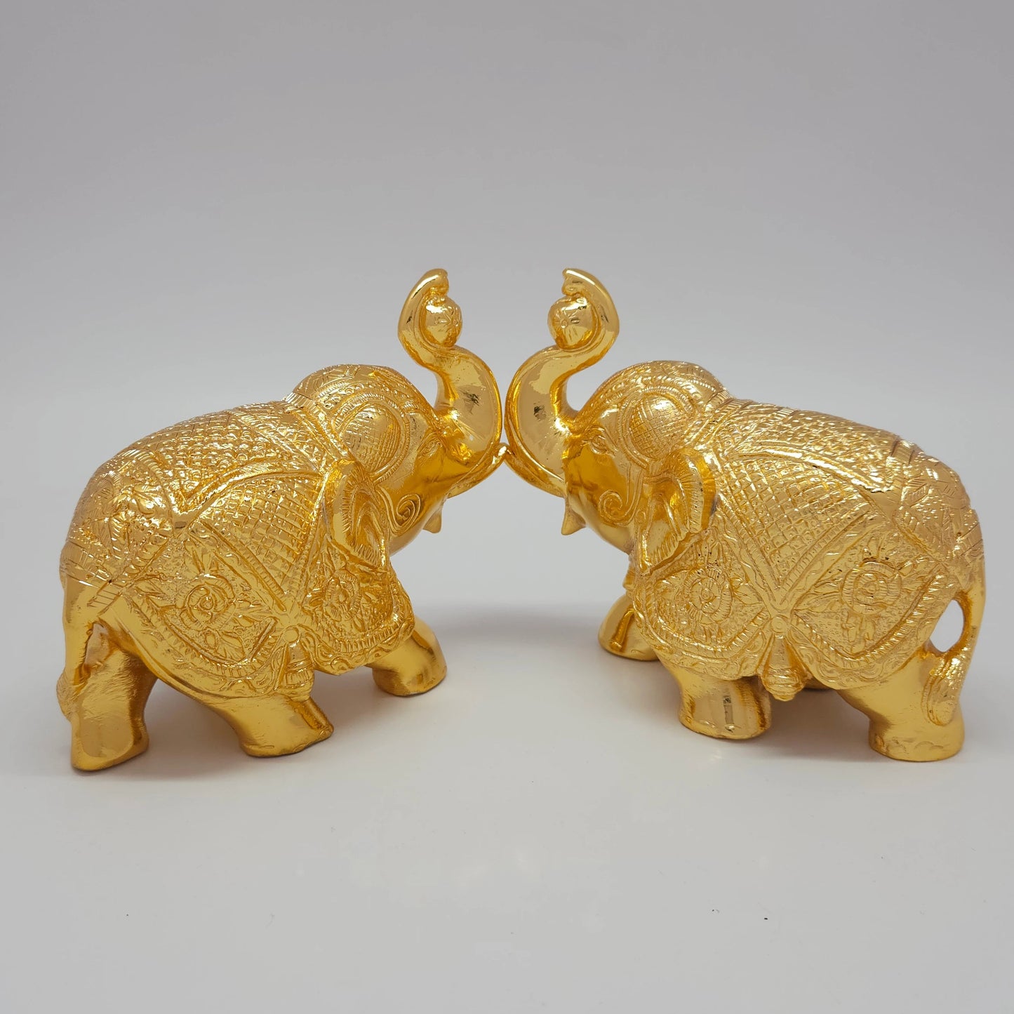 Sri Swaminathan and Co brass elephant statue gold powder coated 4-inch 11cm height posture mirror view facing each other 45-degree side showing uniform satin gold finish layer