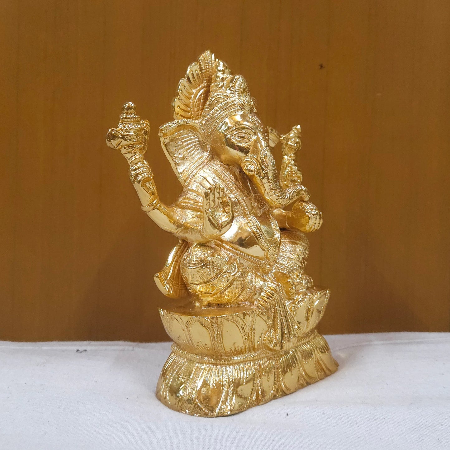 Sri Swaminathan and Co brass Vigneshwara statue gold finish 18.5cm height 45 degree right pose corner view focusing on traditional elephant goad tool and right trunk curve