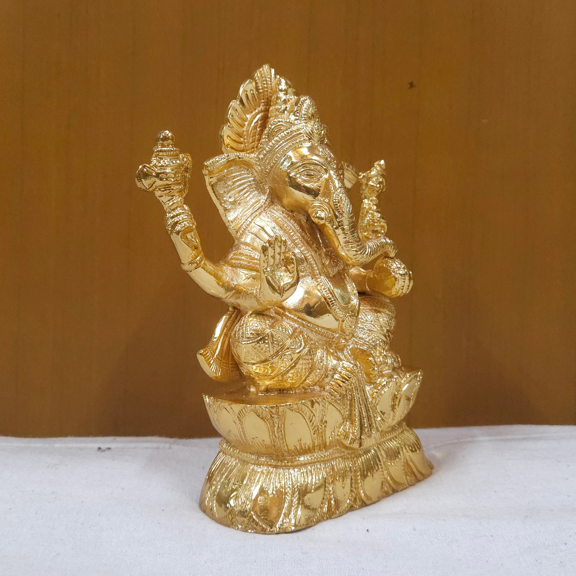 Sri Swaminathan and Co brass Vigneshwara statue gold finish 18.5cm height 45 degree right pose corner view focusing on traditional elephant goad tool and right trunk curve