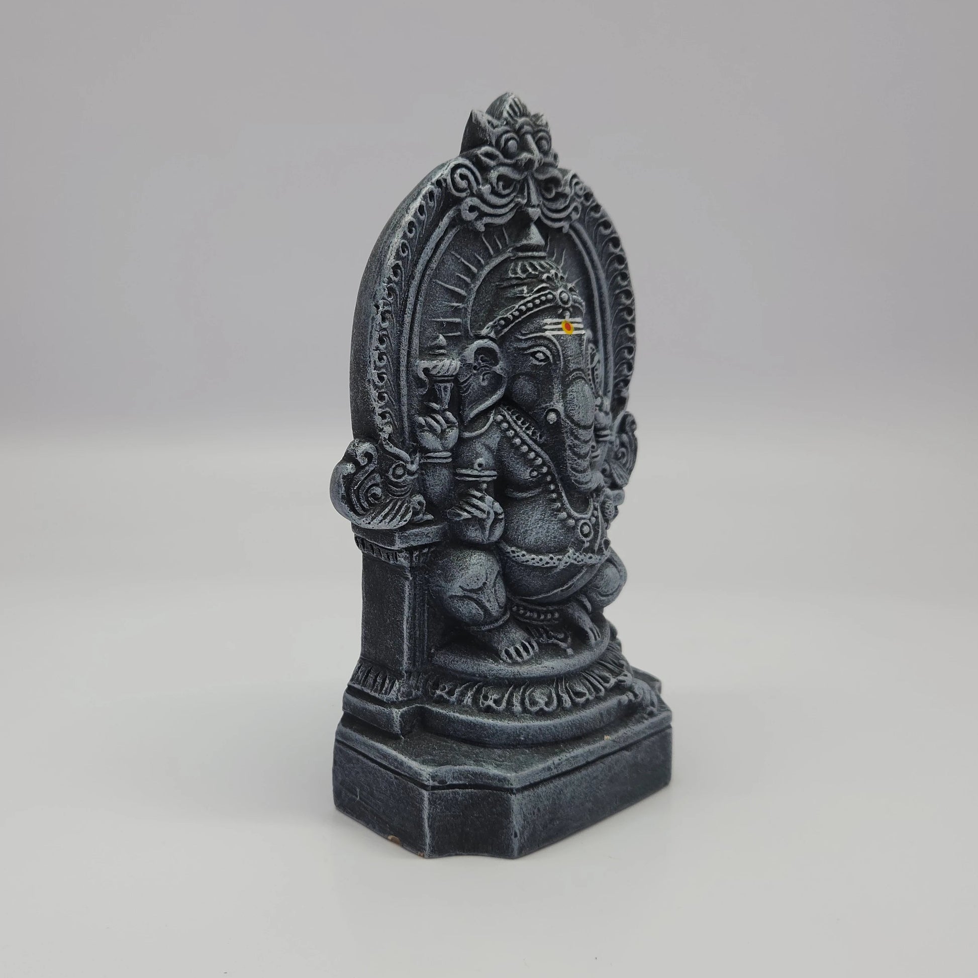 Sri Swaminathan and Co paper mesh Ganesha statue stone finish 16cm height 45 degree right pose corner view focusing on front trunk curve toward modak sweet and base depth