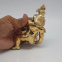 Handheld back profile view of the solid cast Swamimalai Panchaloha Baby Krishna idol verifying the dense five-metal foundry work and smooth rear details.