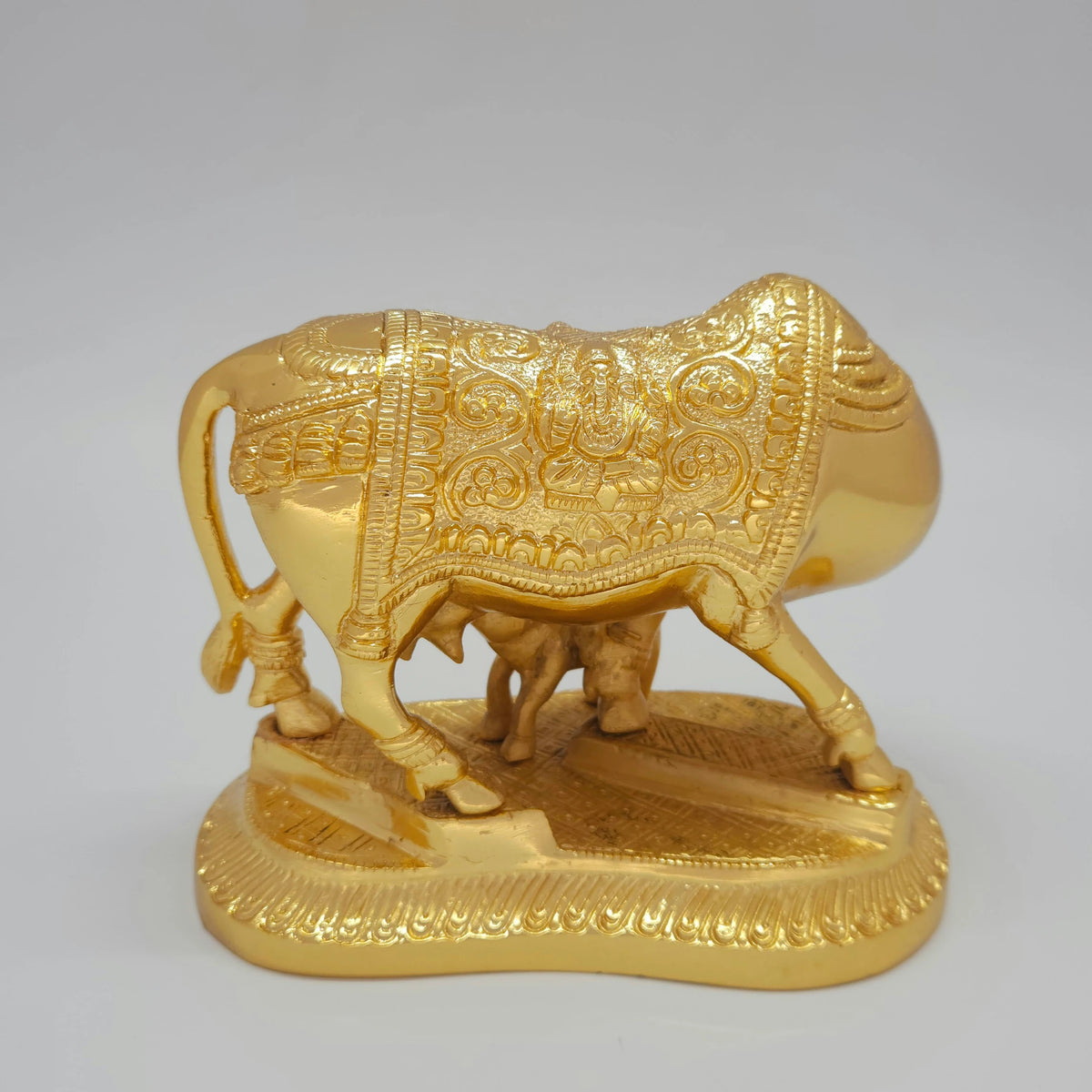 Direct rear back view of the solid brass Kamadhenu cow murti highlighting the polished glossy gold layered finish along the rear blanket.
