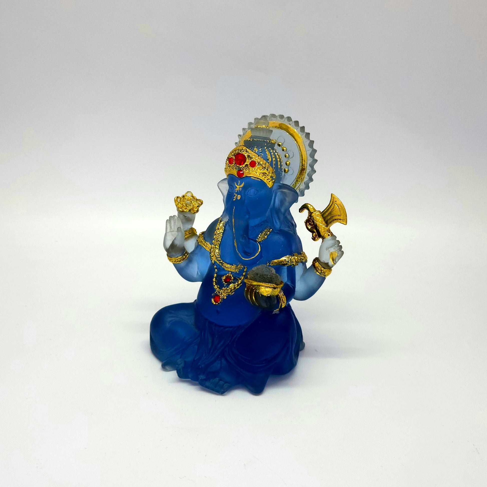 Side angle view showing the glass-like translucent blue resin texture of the Ganesha sculpture.